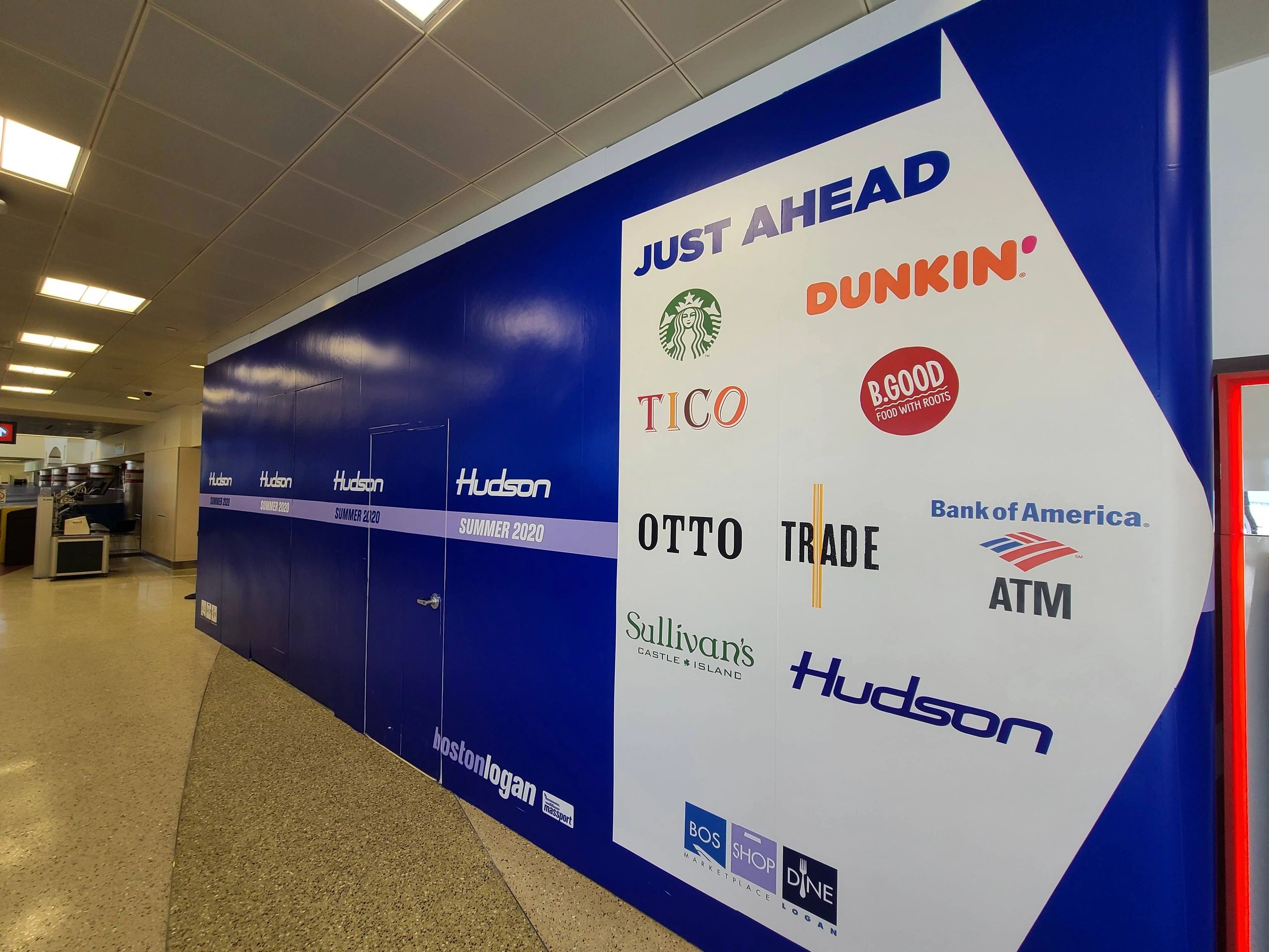 Branded retail wall graphics in a transit concourse